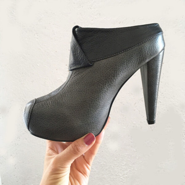 Zapatos elegantes tipo mules de cuero con tacón delgado y plataforma para mujer color gris oscuro. Tiene un corte superior en color negro con un adorno en el mismo tono.