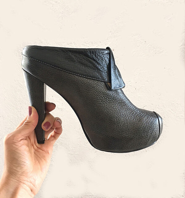 Zapatos elegantes tipo mules de cuero con tacón delgado y plataforma para mujer color gris oscuro. Tiene un corte superior en color negro con un adorno en el mismo tono.