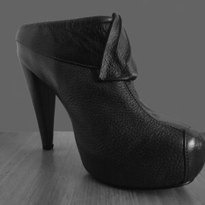 Zapatos elegantes tipo mules de cuero con tacón delgado y plataforma para mujer color gris oscuro. Tiene un corte superior en color negro con un adorno en el mismo tono.