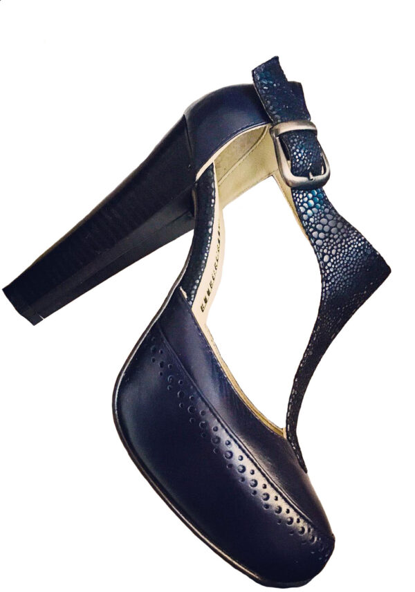 Zapatos tipo T-strap de cuero color azul marino con 2 tipos de texturas. Tacón alto y ancho. Con una hebilla color oro viejo.