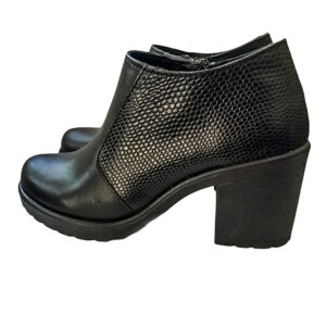 Zapatos abotinados de cuero color negro, de altura media con dos cortes laterales de piel imitación lizzard. Llegan a la atura de los tobillos, se cierran con un cierre que va por el lado interno del zapato. La suela es estilo track, la plataforma mide 1.5 cm, el tacón mide 7cm de alto, es tacón grueso por lo que es un calzado muy cómodo.