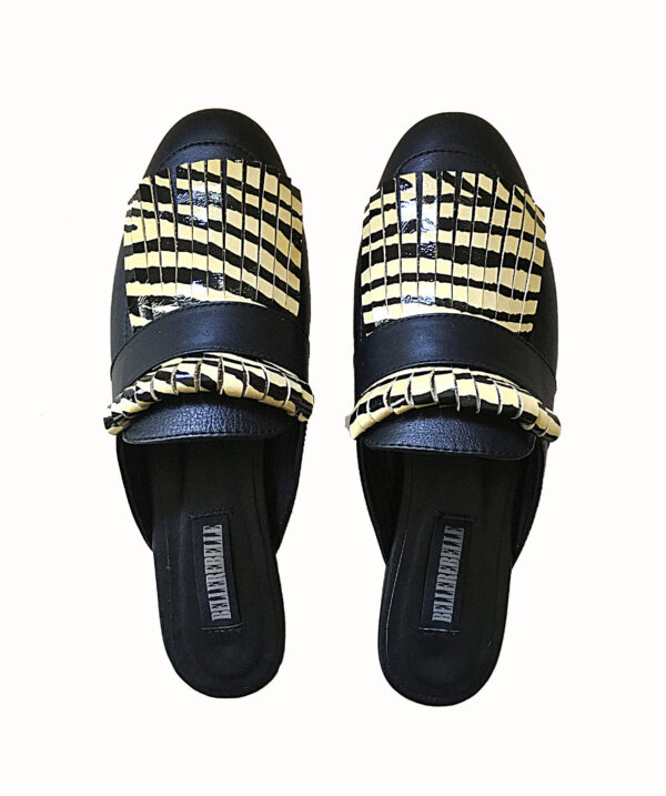 Zapatos tipo zuecos femeninos, de piel color negro, con detalle de “barbas” enfrente de animal print de zebra(color amarillo con negro) que cubre todo el frente del zapato. Encima de esta pieza lleva una tira negra que pasa por lo ancho. Zapatos cómodos, sin tacón alto.