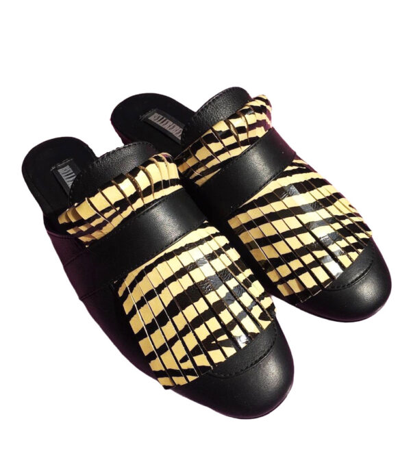 Zapatos tipo zuecos femeninos, de piel color negro, con detalle de “barbas” enfrente de animal print de zebra(color amarillo con negro) que cubre todo el frente del zapato. Encima de esta pieza lleva una tira negra que pasa por lo ancho. Zapatos cómodos, sin tacón alto.